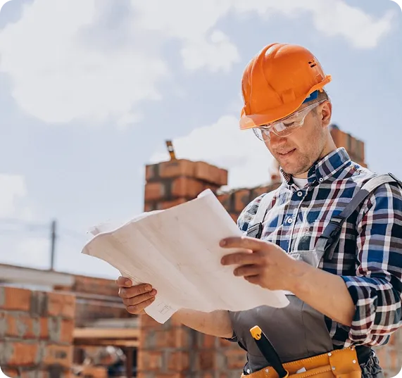 Construction worker reviewing plans for development finance